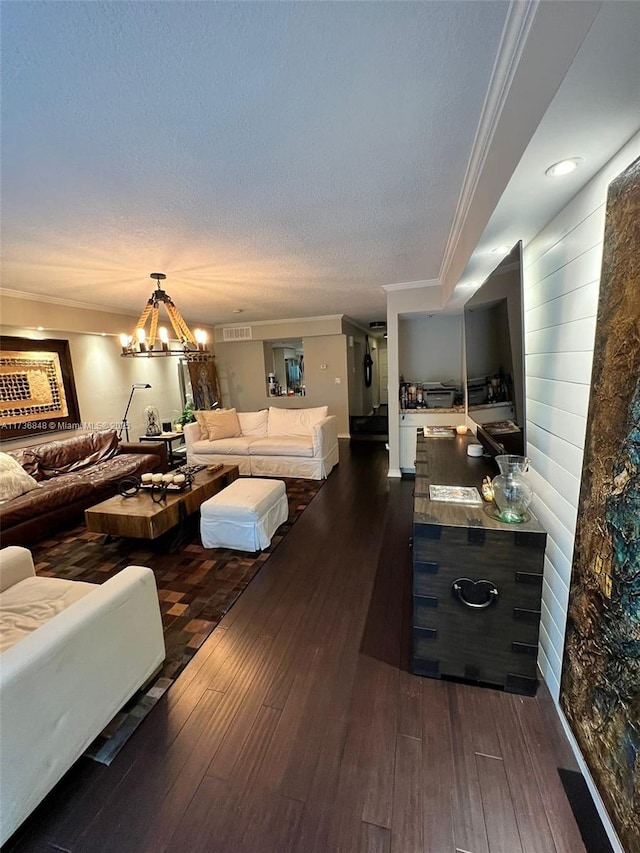 living room with crown molding, an inviting chandelier, and dark hardwood / wood-style flooring