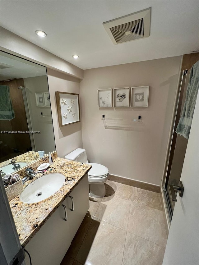 bathroom featuring vanity, a shower with door, and toilet