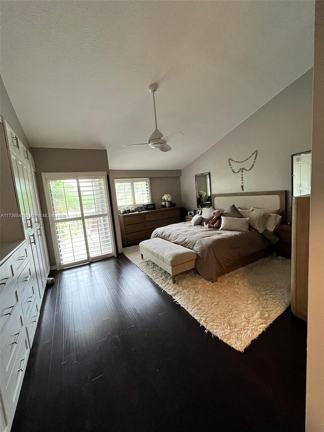 bedroom featuring lofted ceiling, dark wood-type flooring, access to outside, and ceiling fan