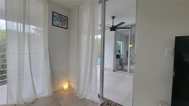 hall featuring floor to ceiling windows and light tile patterned floors