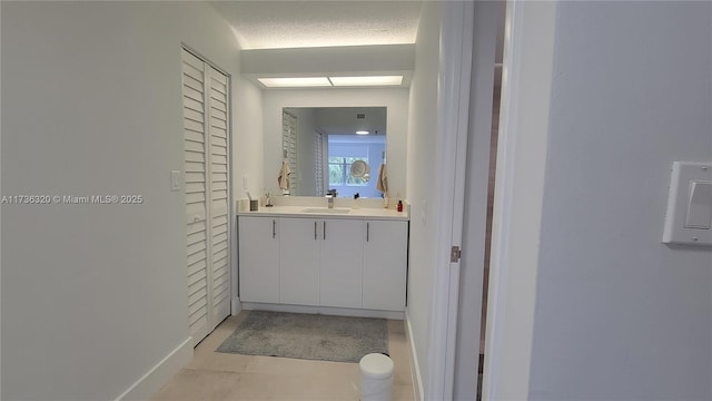 bathroom featuring vanity, tile patterned floors, and a textured ceiling