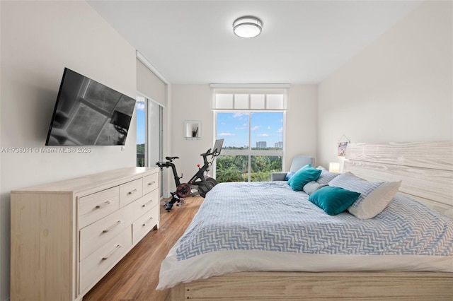 bedroom featuring dark wood-type flooring and expansive windows