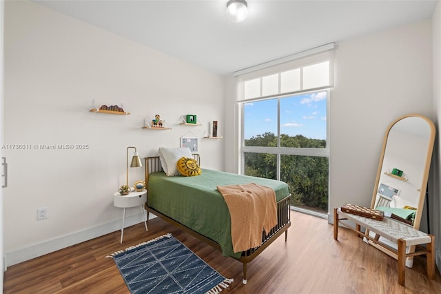 bedroom featuring wood-type flooring and floor to ceiling windows