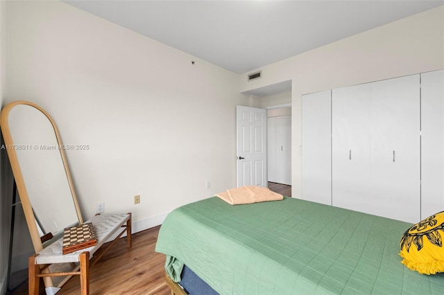 bedroom featuring hardwood / wood-style floors and a closet