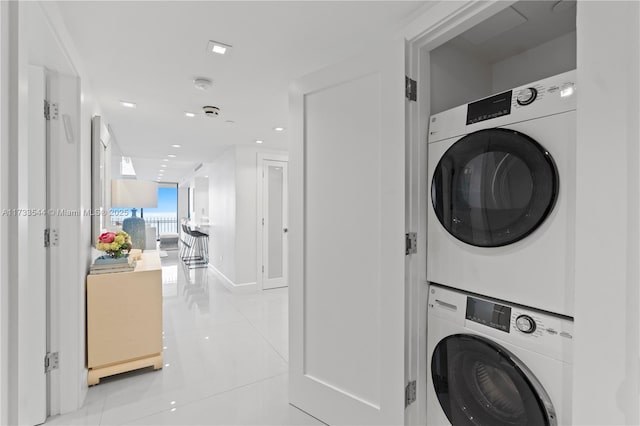 washroom featuring stacked washer and dryer and light tile patterned flooring