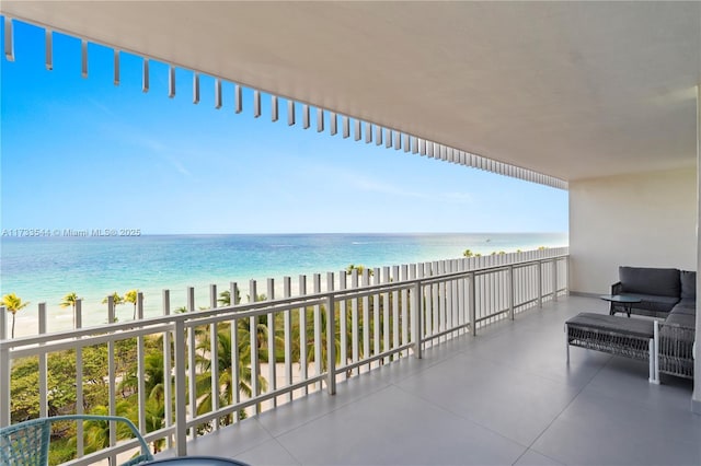 balcony featuring a water view and a beach view