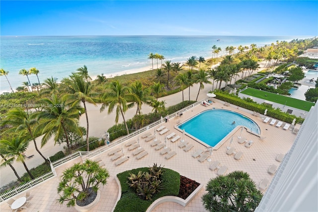 view of swimming pool featuring a water view and a beach view