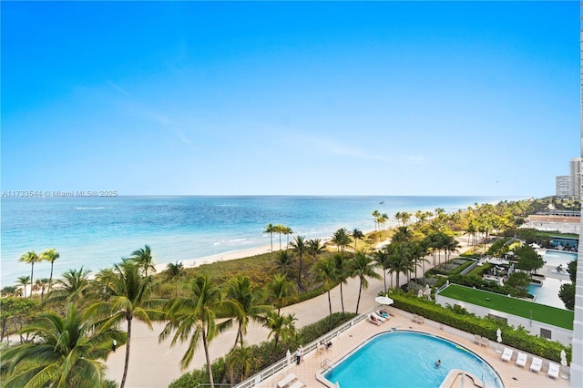 view of pool featuring a patio area, a beach view, and a water view