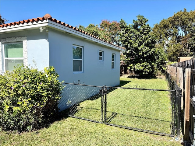 view of home's exterior featuring stucco siding, fence, and a yard