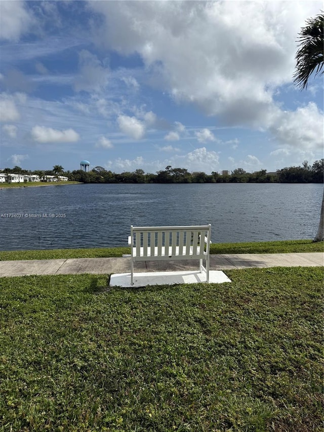 view of dock with a yard and a water view