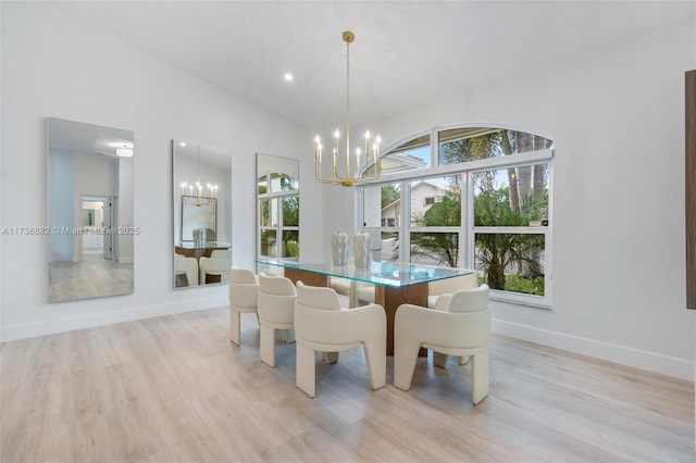 dining room with an inviting chandelier, lofted ceiling, and light hardwood / wood-style floors