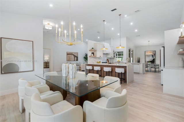 dining space with a notable chandelier, recessed lighting, visible vents, light wood-style flooring, and high vaulted ceiling