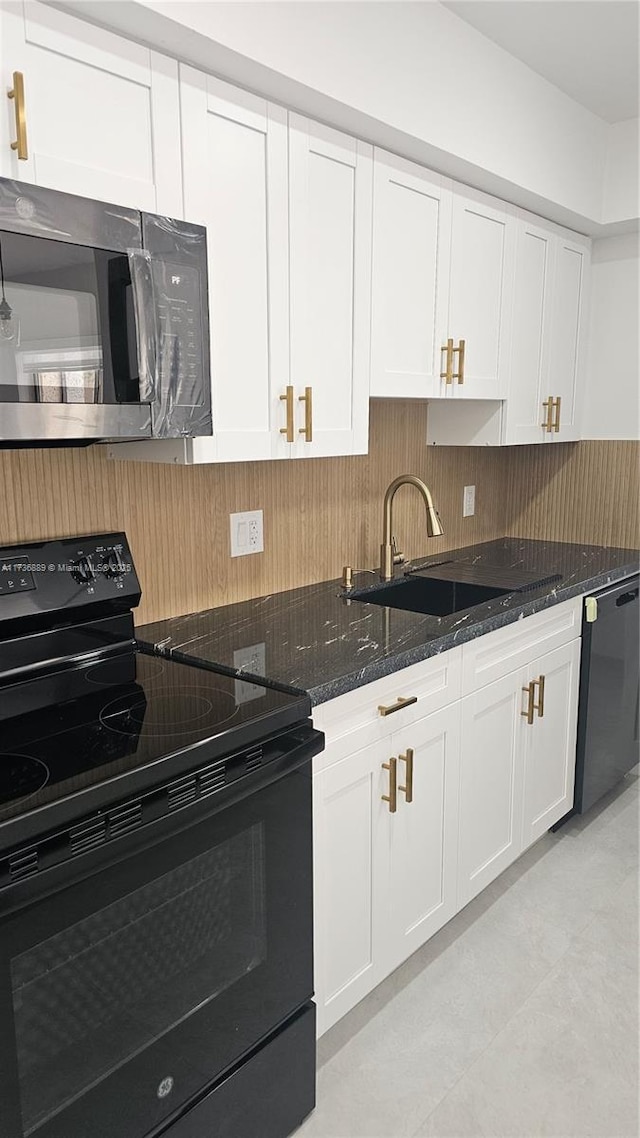 kitchen featuring white cabinetry, sink, decorative backsplash, dark stone counters, and black appliances