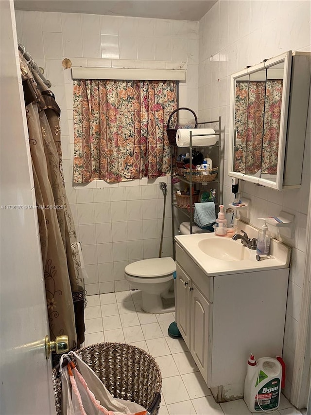 bathroom with tile patterned flooring, vanity, tile walls, and toilet