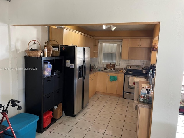 kitchen with appliances with stainless steel finishes, light brown cabinetry, sink, decorative backsplash, and light tile patterned floors