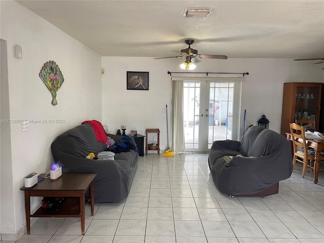 tiled living room featuring french doors and ceiling fan