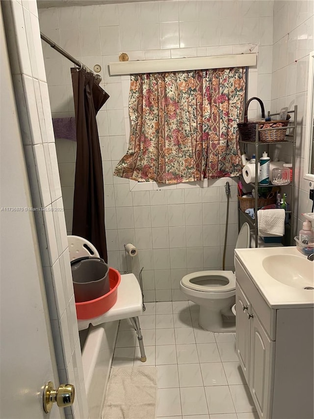 full bathroom featuring shower / tub combo with curtain, tile walls, vanity, tile patterned floors, and toilet