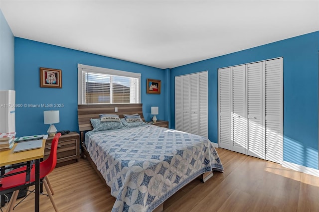 bedroom featuring two closets and light wood-type flooring