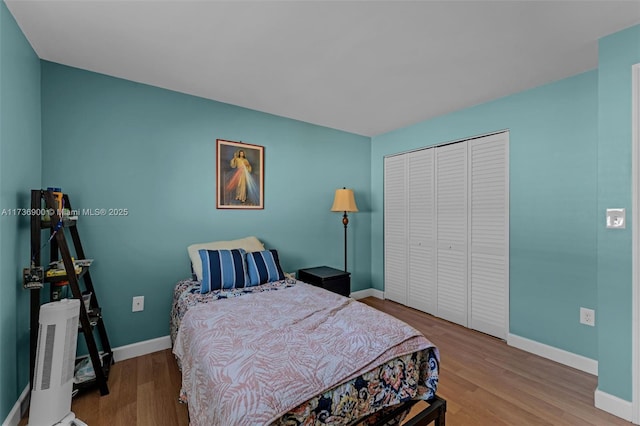 bedroom with light hardwood / wood-style floors and a closet