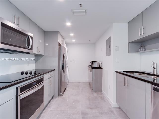 kitchen featuring stainless steel appliances, sink, and gray cabinetry