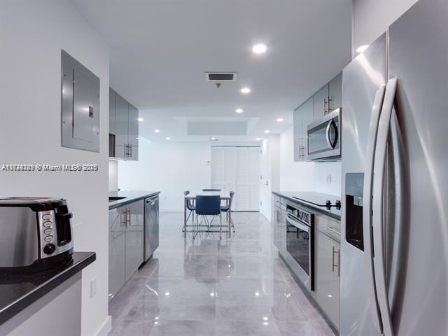 kitchen featuring stainless steel appliances, gray cabinets, and electric panel