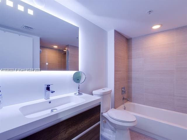 full bathroom with vanity, toilet, and tiled shower / bath