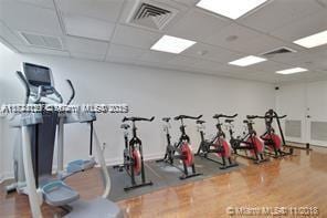 workout room featuring hardwood / wood-style flooring and a paneled ceiling