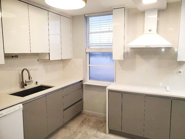 kitchen with sink, gray cabinetry, decorative backsplash, white dishwasher, and wall chimney exhaust hood