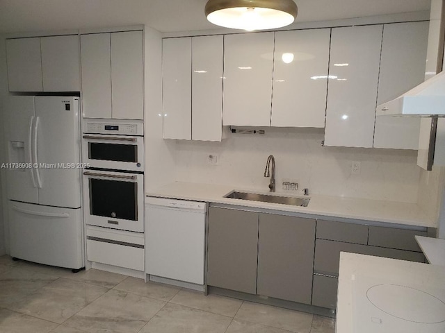 kitchen featuring sink, white cabinets, white appliances, and wall chimney exhaust hood