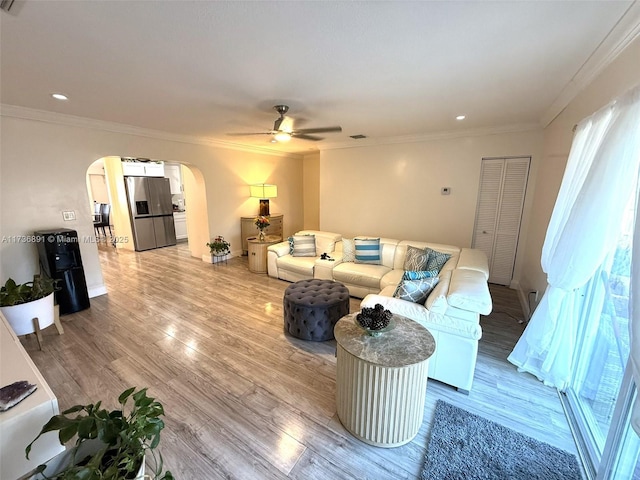 living room featuring crown molding, ceiling fan, and light hardwood / wood-style floors