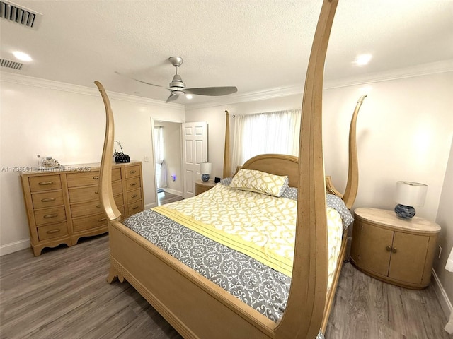 bedroom featuring dark hardwood / wood-style flooring, crown molding, and a textured ceiling