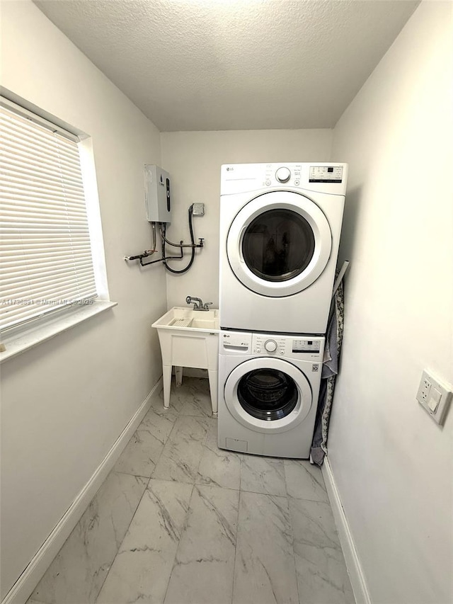 laundry room featuring stacked washer and clothes dryer and a textured ceiling