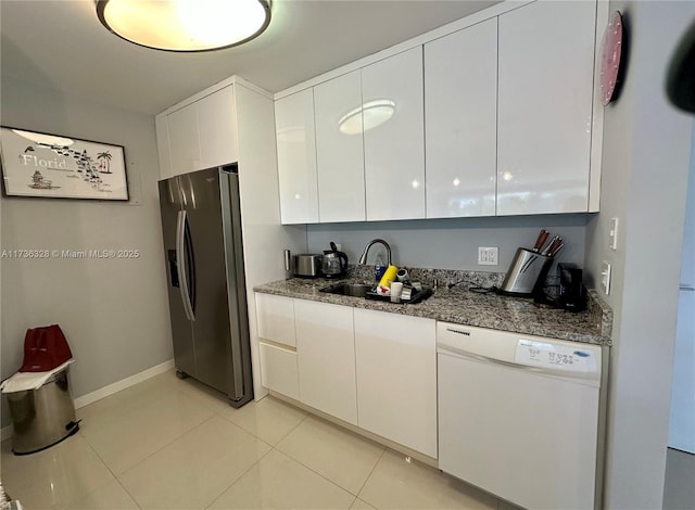 kitchen featuring white cabinetry, stainless steel fridge with ice dispenser, light tile patterned floors, dishwasher, and dark stone counters