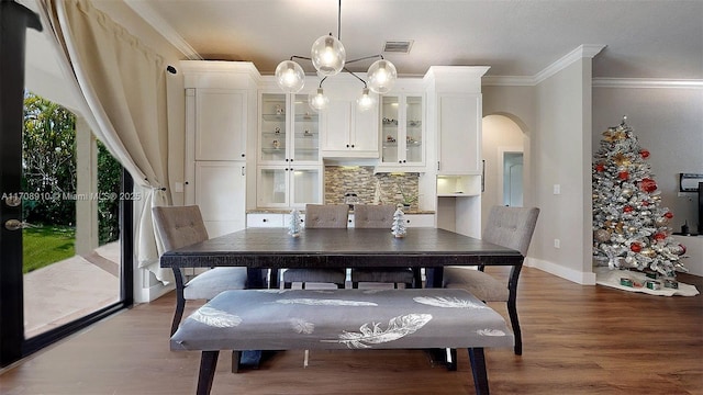 dining area featuring hardwood / wood-style floors and ornamental molding