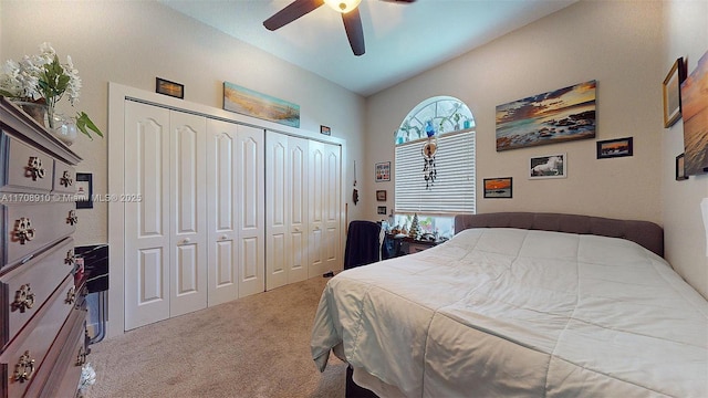 bedroom with vaulted ceiling, a closet, ceiling fan, and carpet