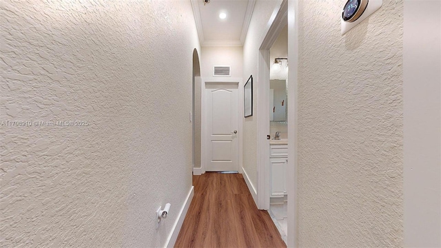 corridor with crown molding and hardwood / wood-style flooring