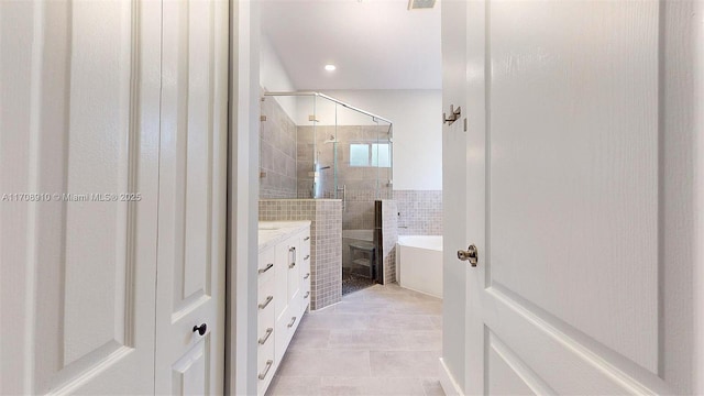 bathroom featuring vanity, tile patterned floors, tile walls, and separate shower and tub