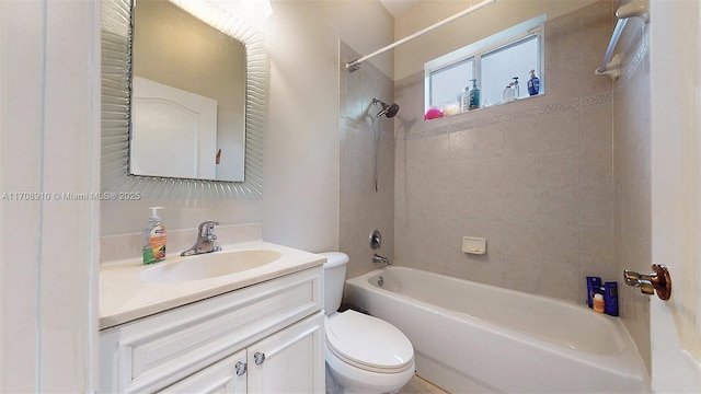 full bathroom featuring tiled shower / bath, vanity, and toilet