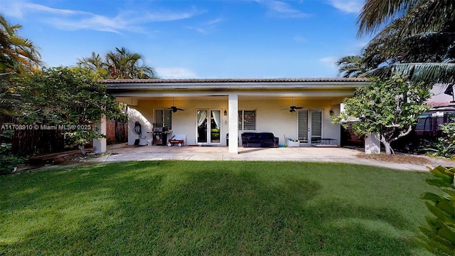 back of house with ceiling fan, a patio area, and a lawn