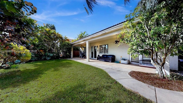 view of yard featuring ceiling fan and a patio area