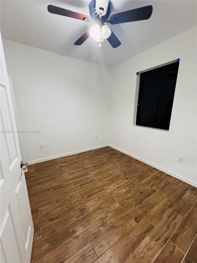 spare room with a ceiling fan, baseboards, and wood finished floors