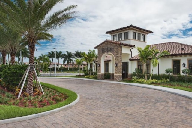 exterior space with a tiled roof, decorative driveway, and stucco siding