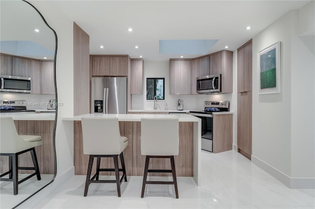 kitchen with appliances with stainless steel finishes, a kitchen bar, sink, and decorative backsplash