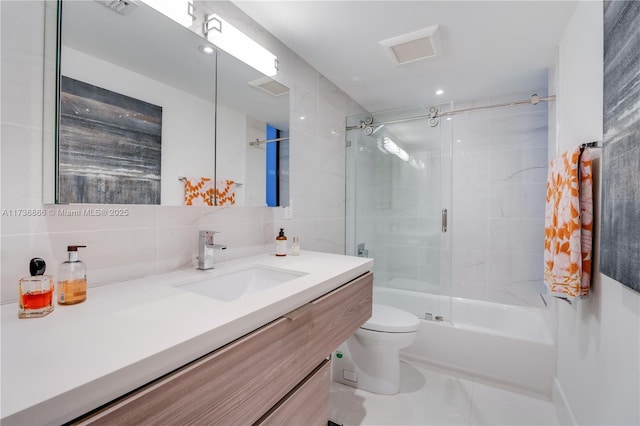 full bathroom with toilet, tasteful backsplash, tile walls, vanity, and enclosed tub / shower combo