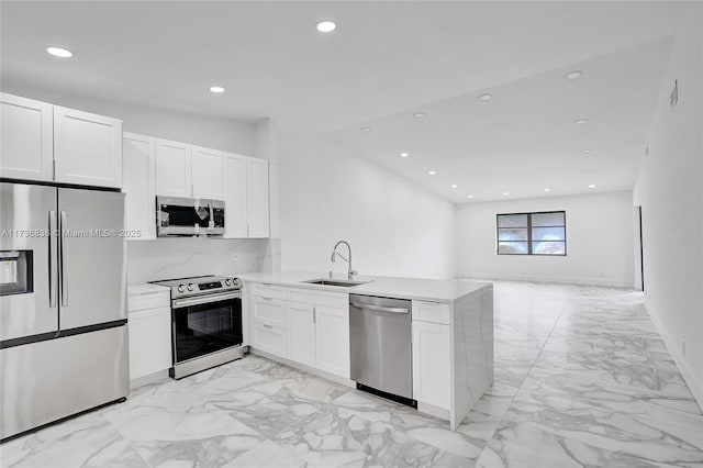 kitchen featuring a sink, white cabinets, open floor plan, light countertops, and appliances with stainless steel finishes