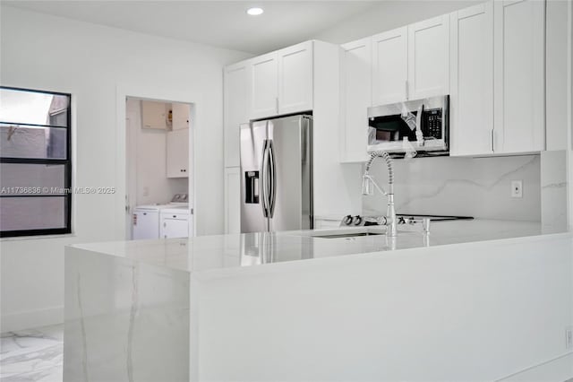 kitchen with white cabinets, washer and clothes dryer, marble finish floor, stainless steel appliances, and recessed lighting