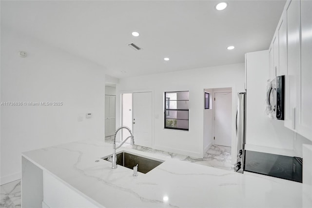 kitchen with visible vents, light stone countertops, marble finish floor, white cabinetry, and a sink