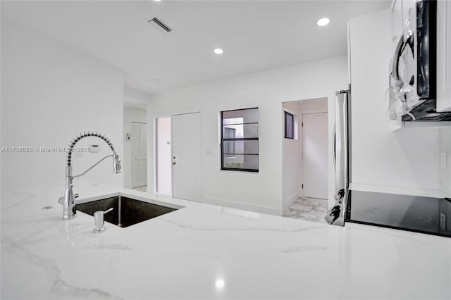 kitchen featuring visible vents, light stone counters, marble finish floor, a sink, and recessed lighting