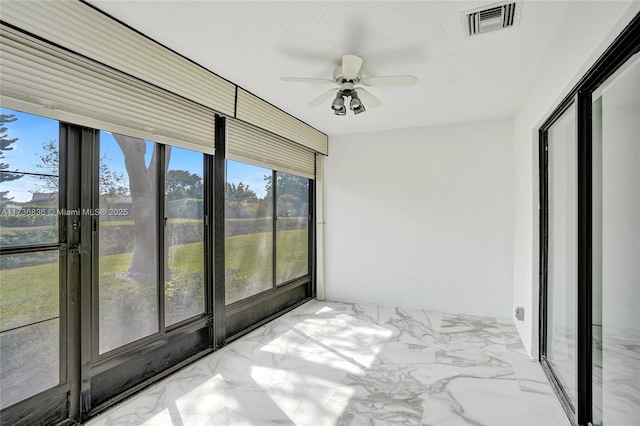 unfurnished sunroom with a ceiling fan and visible vents