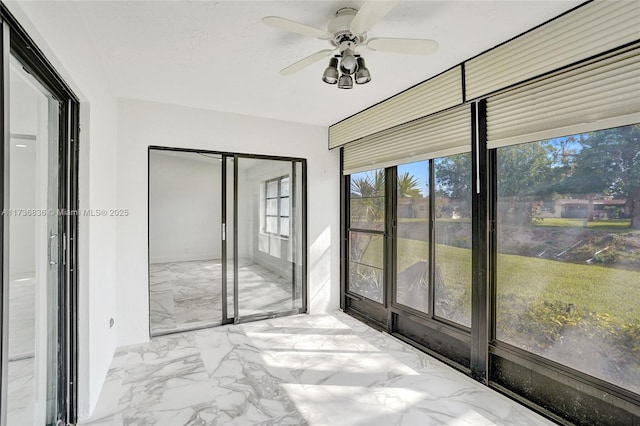 unfurnished sunroom with ceiling fan